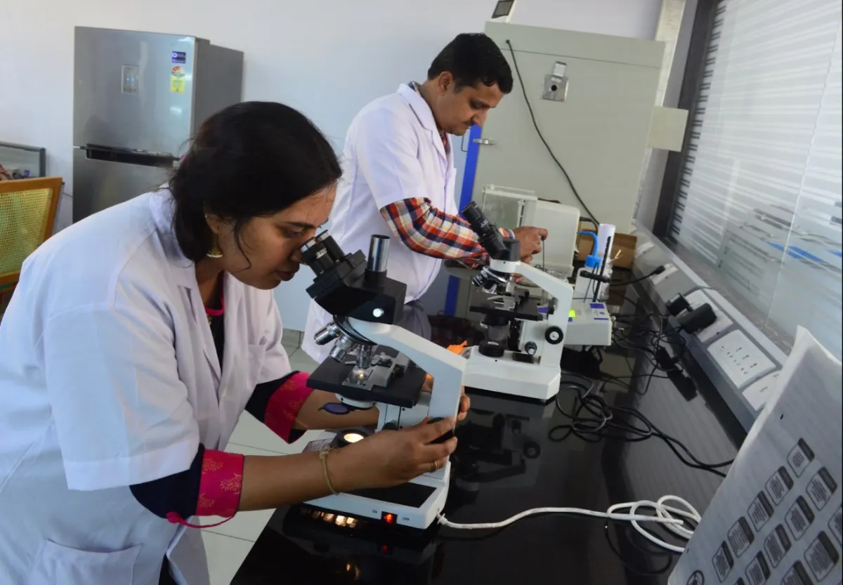 Nuvohelix researchers examining samples under microscopes in the R&D laboratory